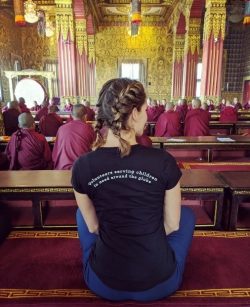 young woman sitting with monks