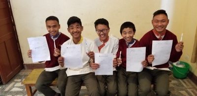 smiling boys with toothbrushes and papers