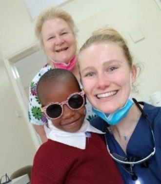 Women dental hygienists with cool kid in sunglasses