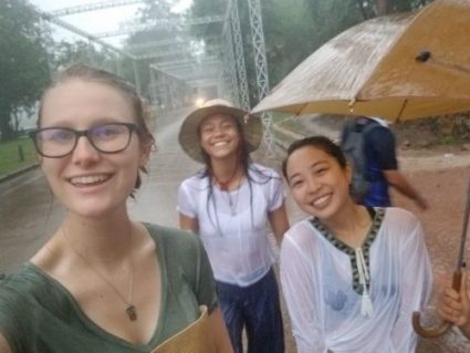 Women in pouring rain take selfie and having fun.