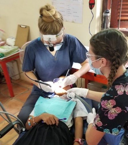 Women dental hygienists working on a young girl, helping her get a clean and healthy smile.