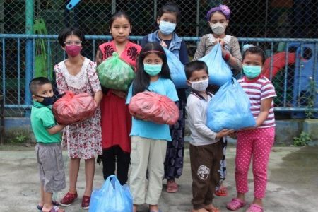 Nepal children holding bags of food for their families