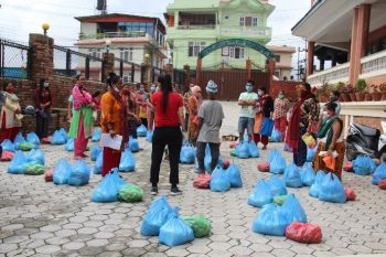 Group of volunteers organizing food supplies into piles for families