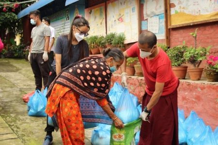 Volunteers putting bags of food into large bags for families