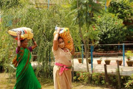 Women carrying bags of food on their head home to their families.