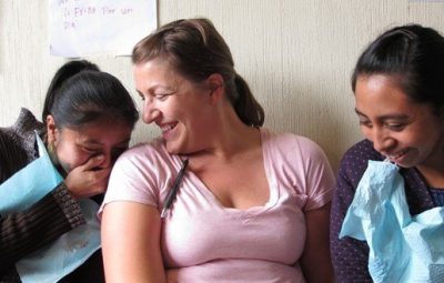 dental volunteer with two girls smiling