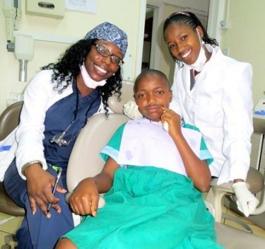 two dentists treating young girl's smile