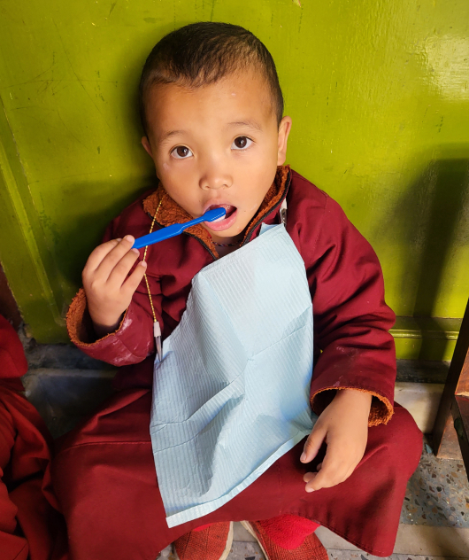 Child eating from a bowl of food that your monthly donation could help provide